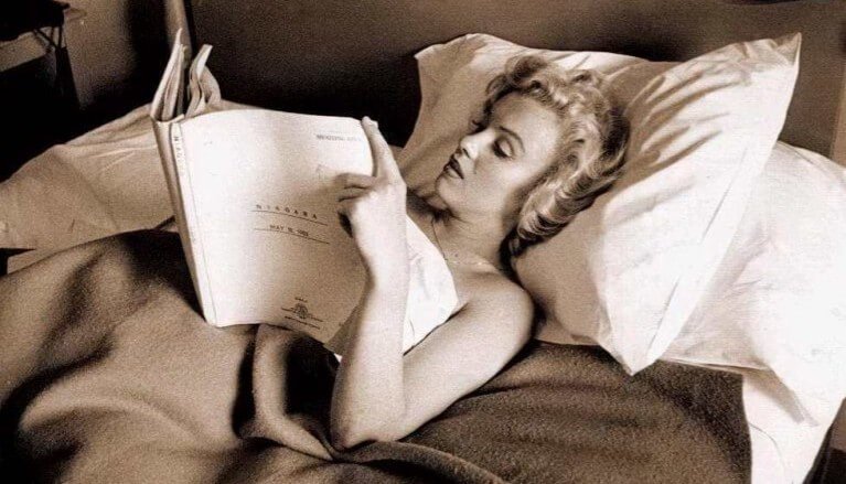 Marilyn Monroe reading a screenplay in bed