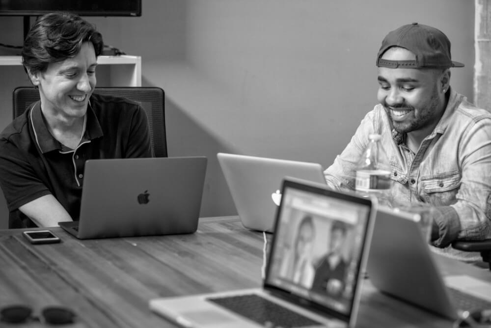 Two screenwriters laughing while writing