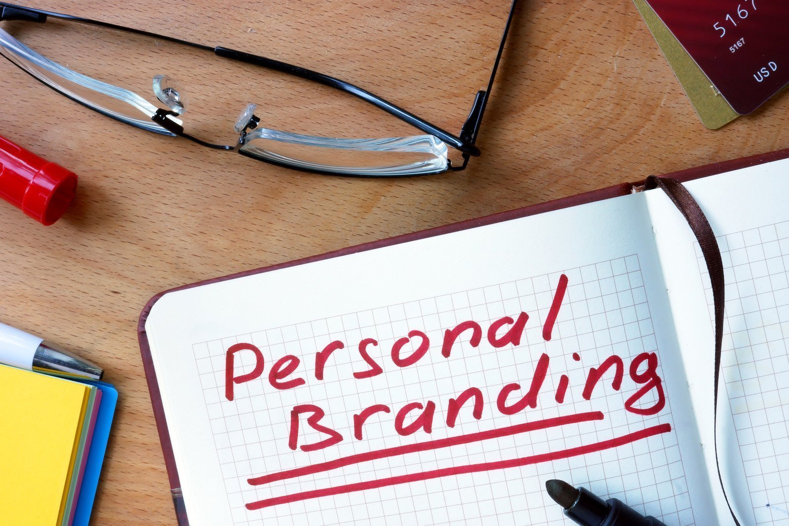 Notepad with Personal Branding on office wooden table.