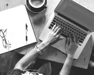 woman writing on a laptop