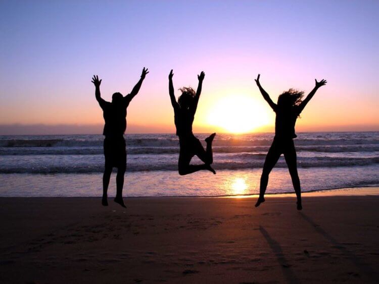 people jumping in the air at the beach
