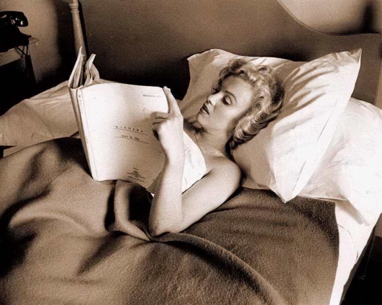 Marilyn Monroe reading a screenplay in bed