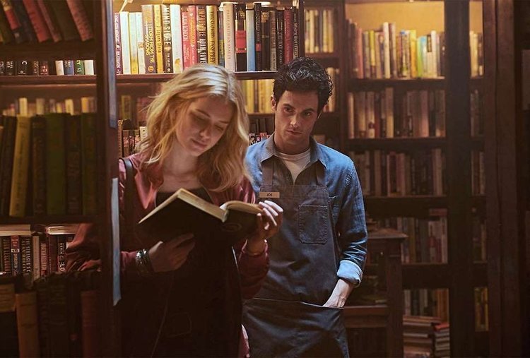 man staring at woman reading